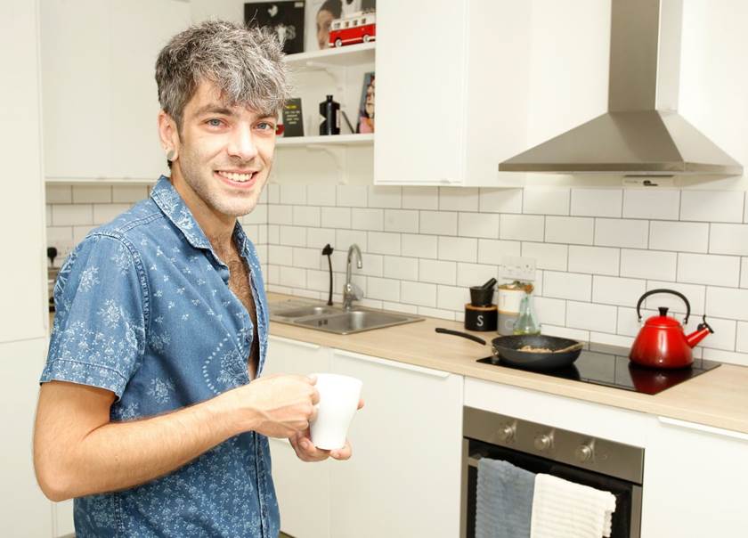 Man stood in kitchen with coffee cup