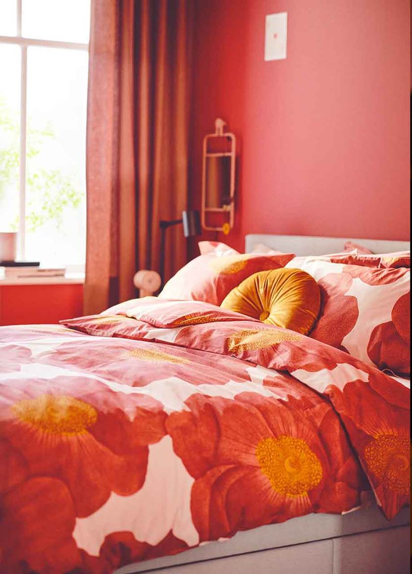 Bed with bright bedding in red, orange and white