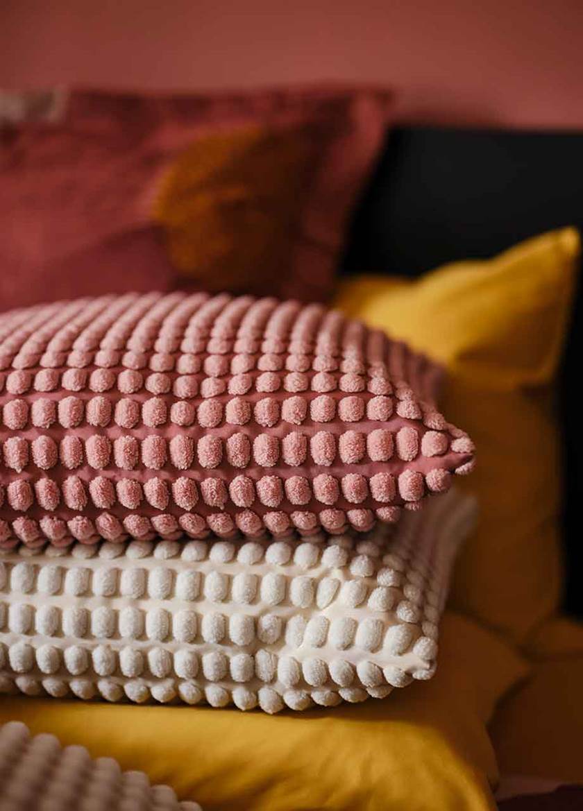 Pile of cushions in red, cream and yellow