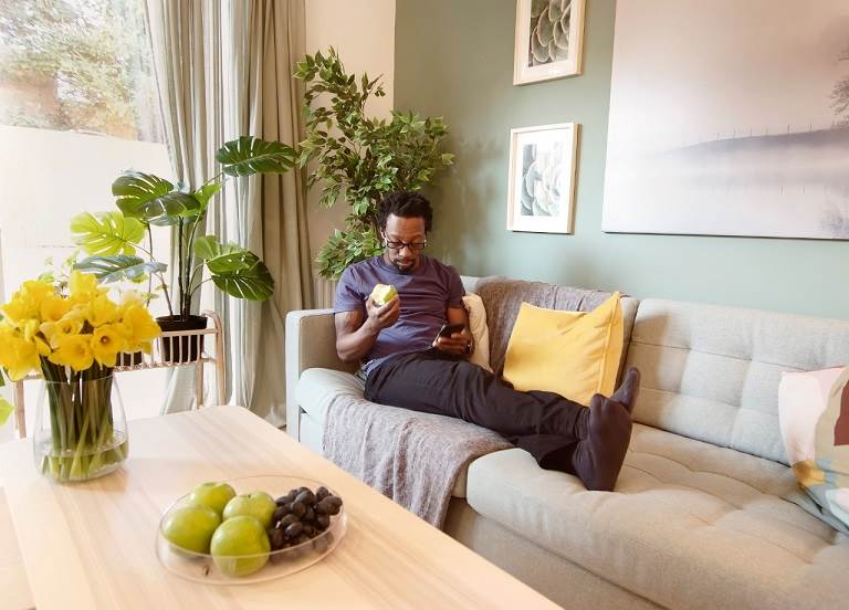 Man sat on sofa looking at phone  Man sat on sofa looking at phone