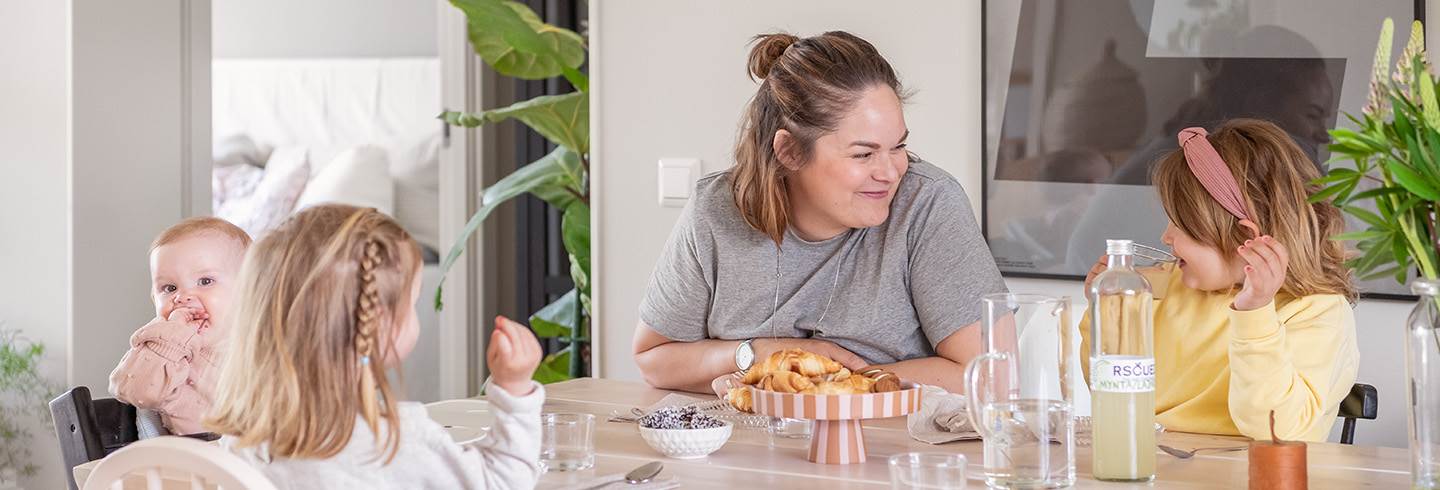 Mother and three children at dining table.