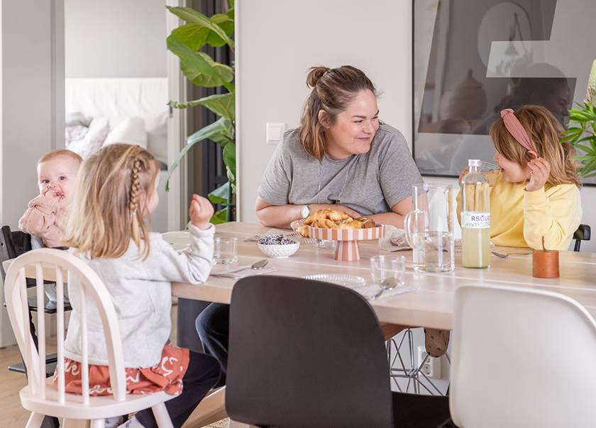 Mother and three children at dining table.